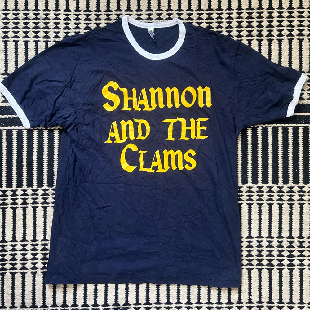 Shannon and the Clams band tee blue with yellow letterings and white trim.